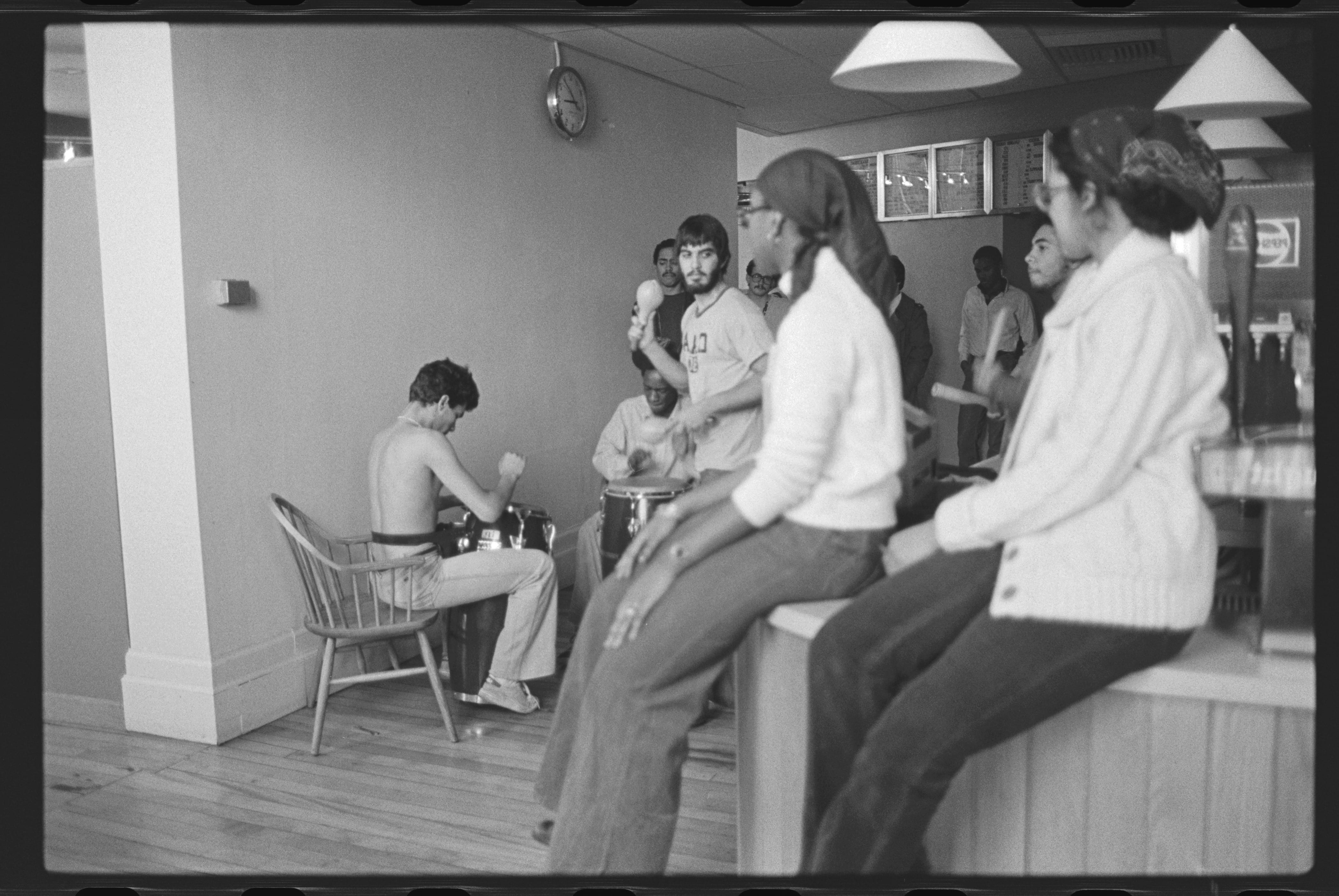 Image of several students in Fayerweather snack bar, some playing music
