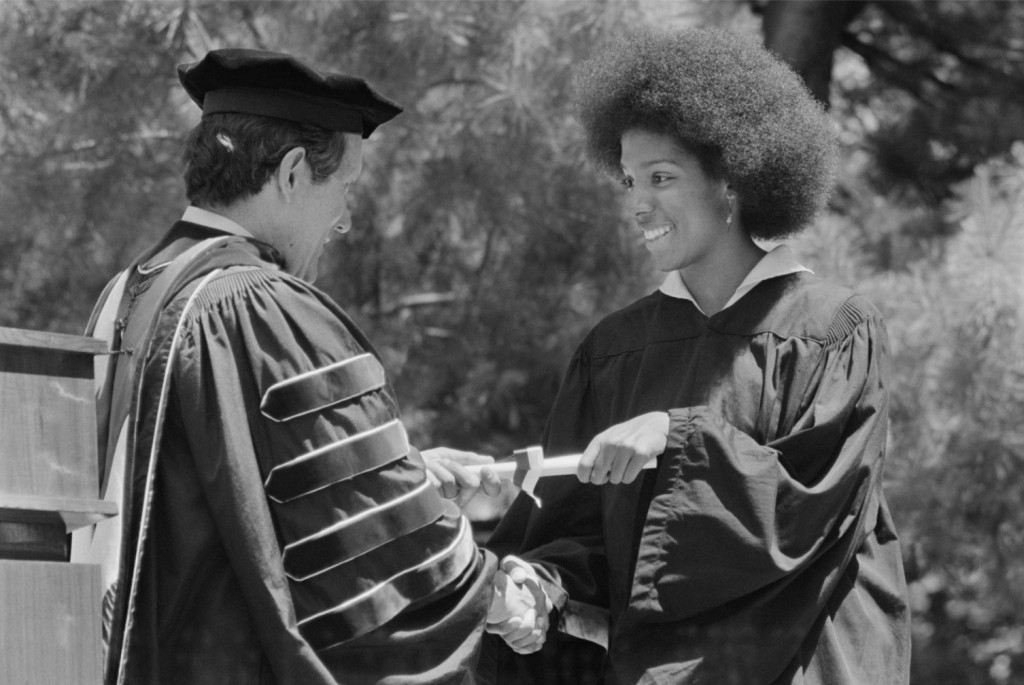 black and white photograph of Lucia Butts receiving her diploma
